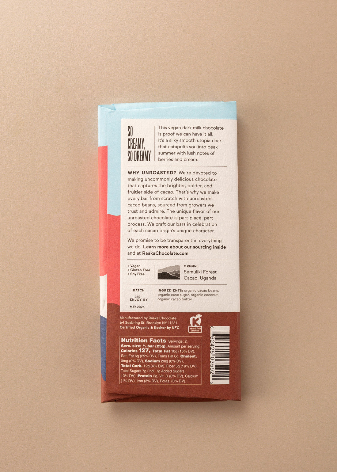backside flatlay of the coconut milk chocolate bar by Raaka with details on the ingredients, why they use unroasted chocolate, and nutrition facts