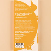 backside flatlay of the golden milk sted 38% white chocolate bar, with details on the ingredients and nutrition facts