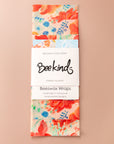 Set of 3 beeswax wraps folding with a white label saying "beekind" on a pink flatlay