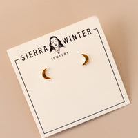 flatlay of a jewelry card stating "sierra winter jewelry" with two crescent moon gold studs on it.