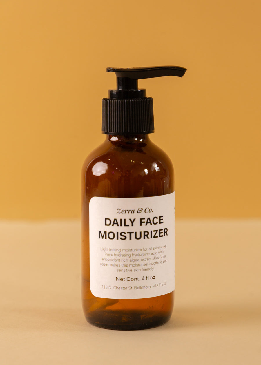 yellow background with an amber pump bottle in the foreground with a white label stating "daily face moisturizer"