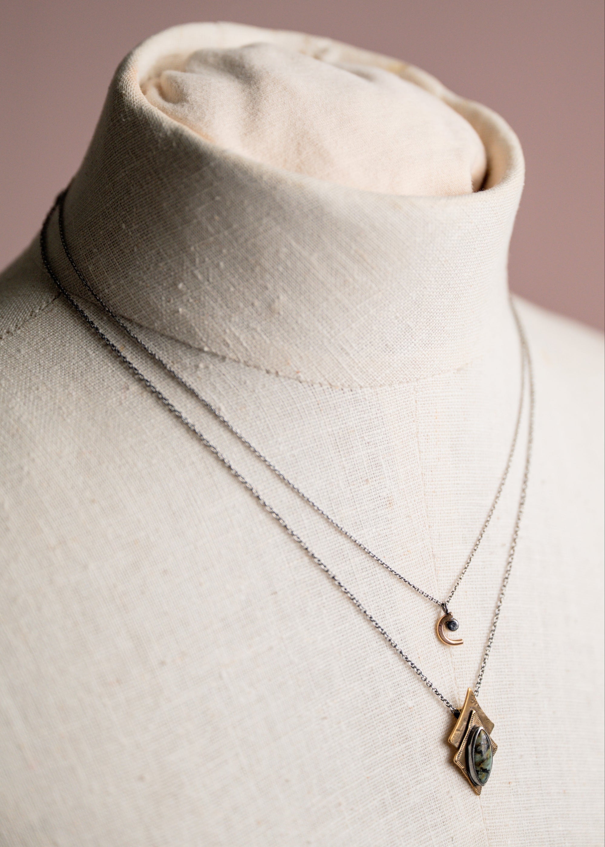 Necklace with a pendant on a mannequin bust against a neutral background