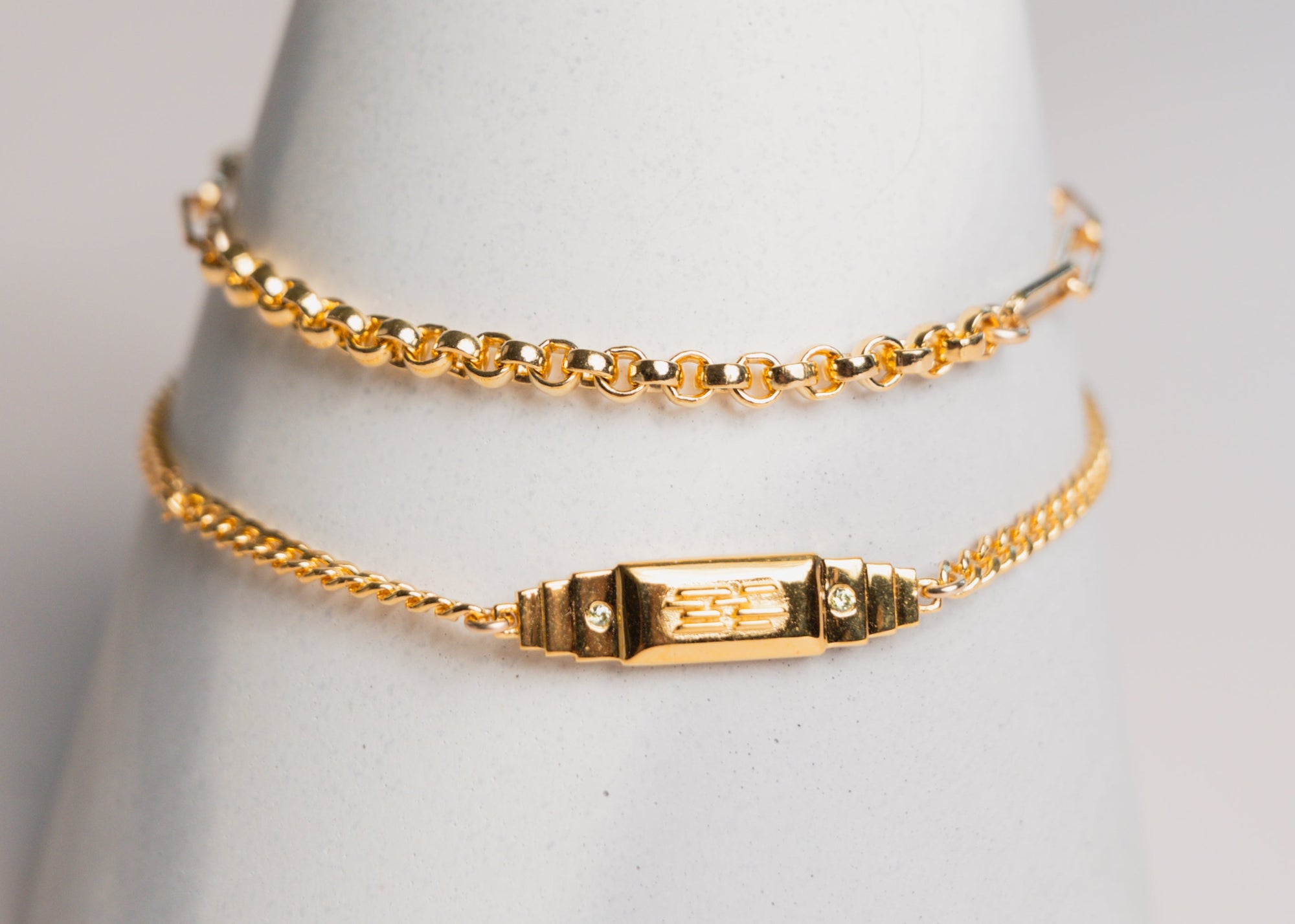 gold bracelets by gwen beloti on white concrete wrist display