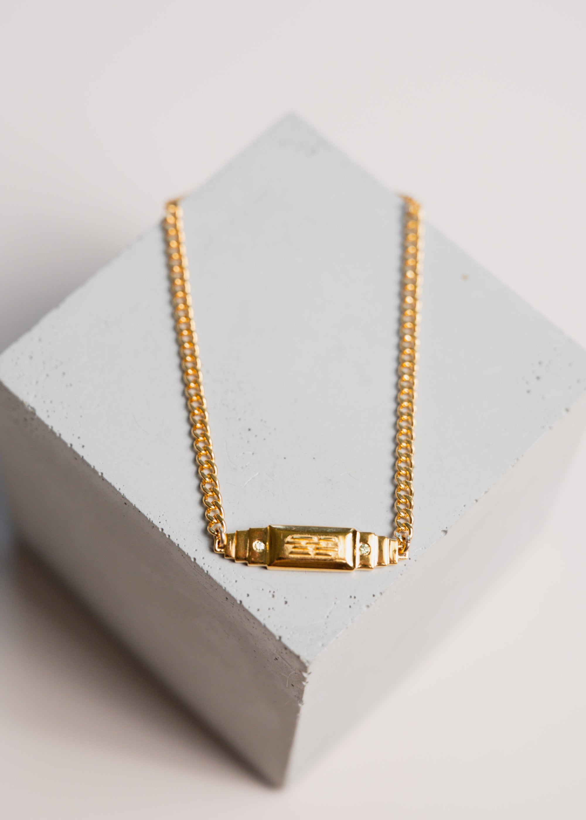 gold bar bracelet by gwen beloti on concrete display