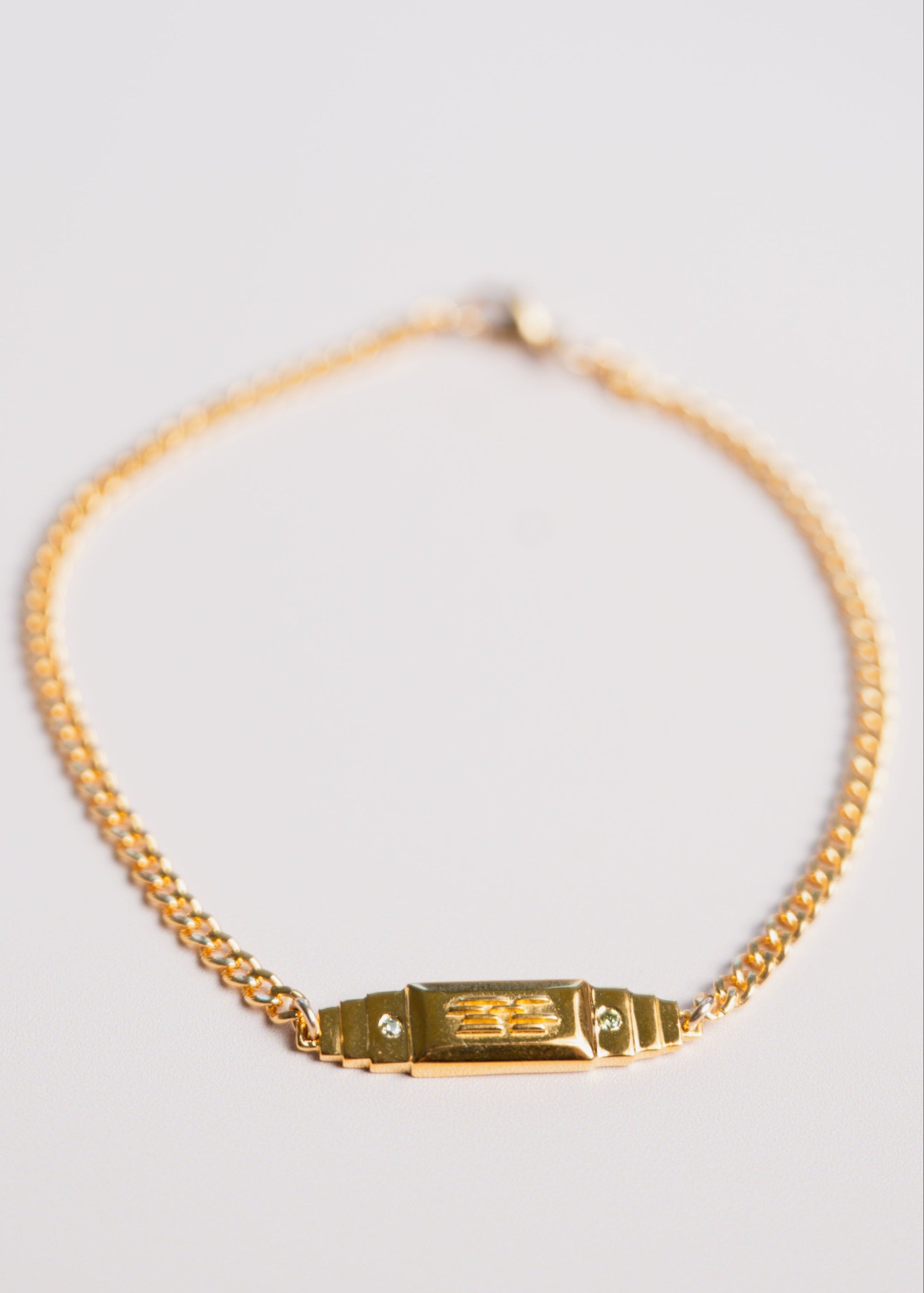 gold bar bracelet by gwen beloti on pink background