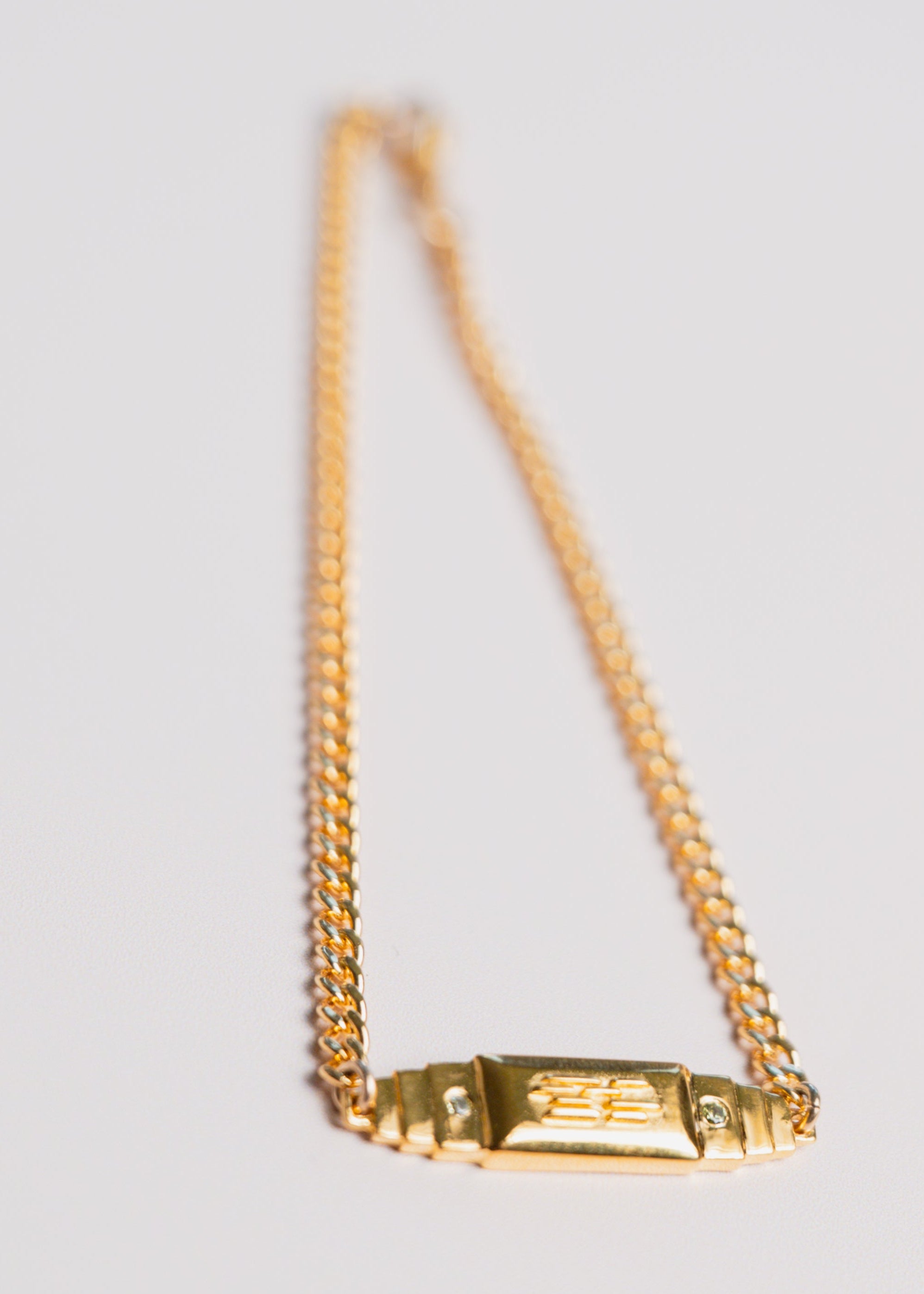 gold bar bracelet by gwen beloti on pink background