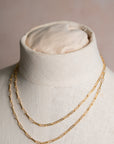 Gold chain necklace on a mannequin bust with a neutral background