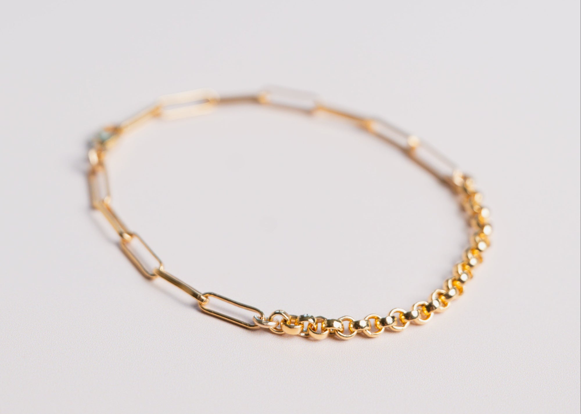 Gold two chain bracelet by gwen beloti on a pink background
