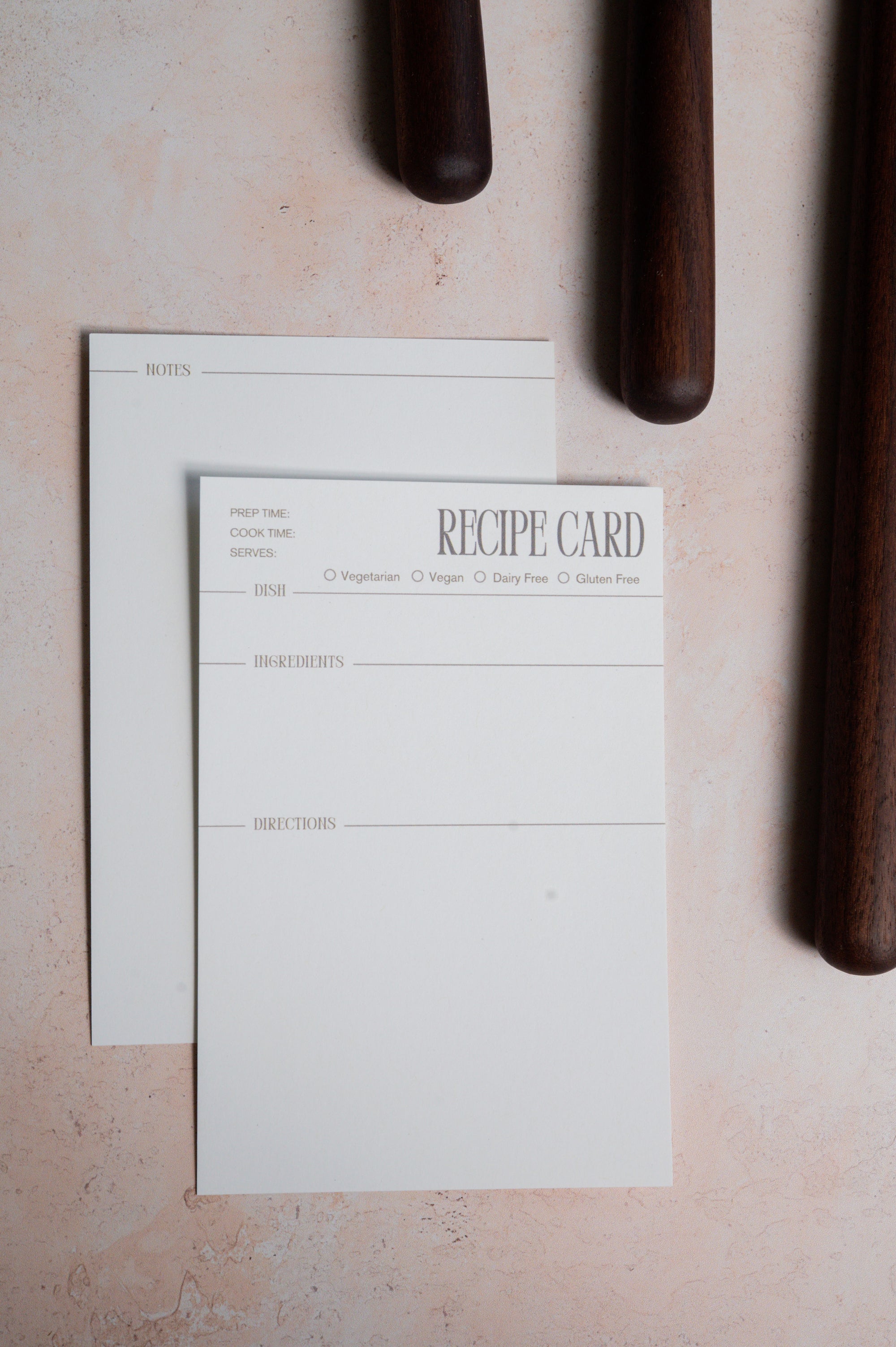 Recipe card front and back shown on a light surface with dark cylindrical objects