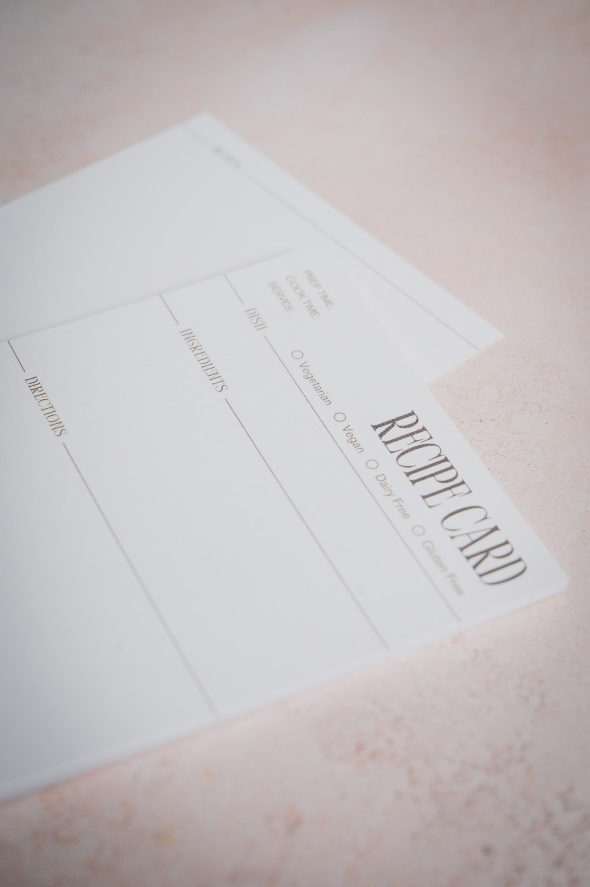 Modern recipe card shown close up on a pink surface