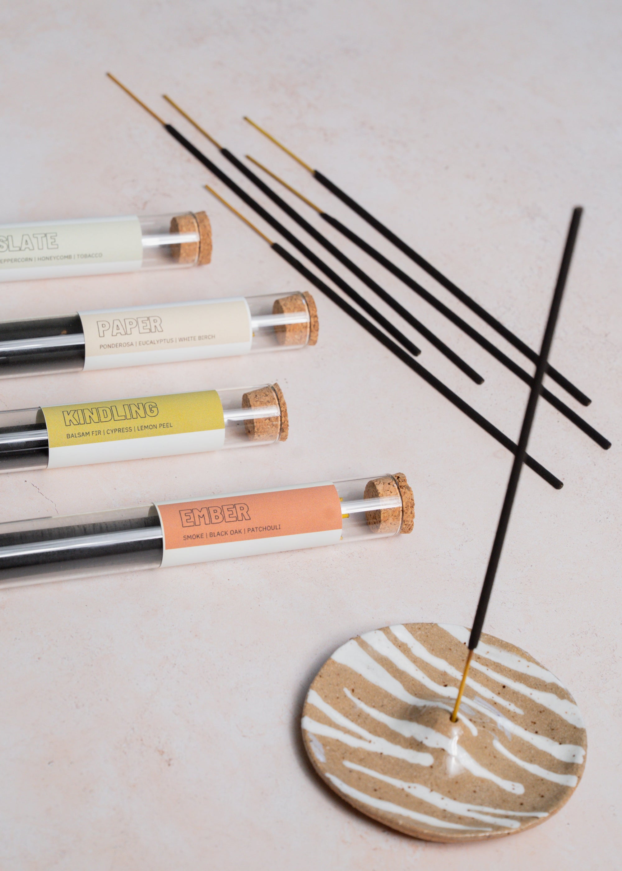 Incense sticks with glass packaging on a light surface with zebra pattern incense holder