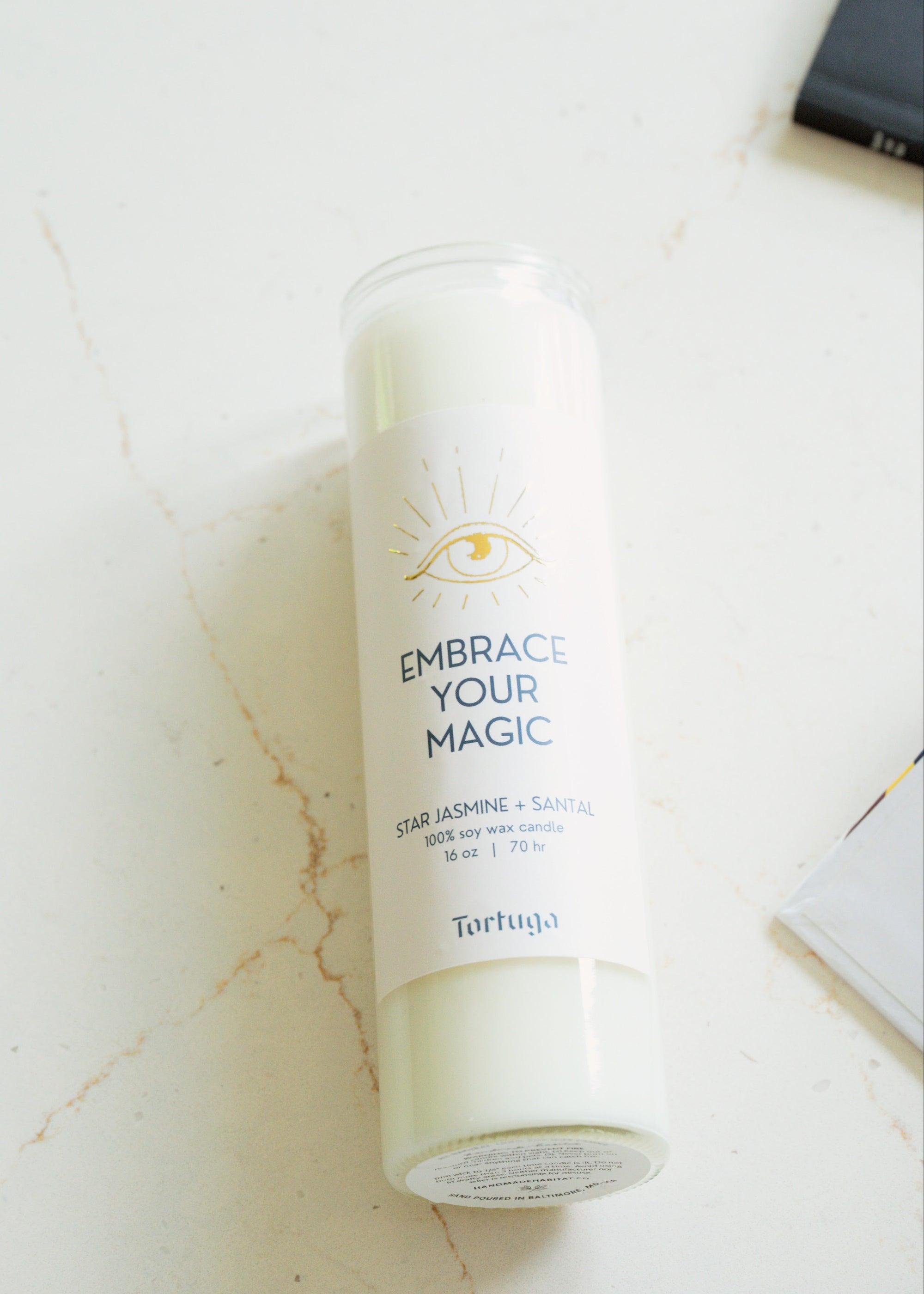 Tortuga candle with 'Embrace Your Magic' text on a light background