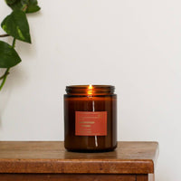A Lit Persimmon and Smoke Candle 