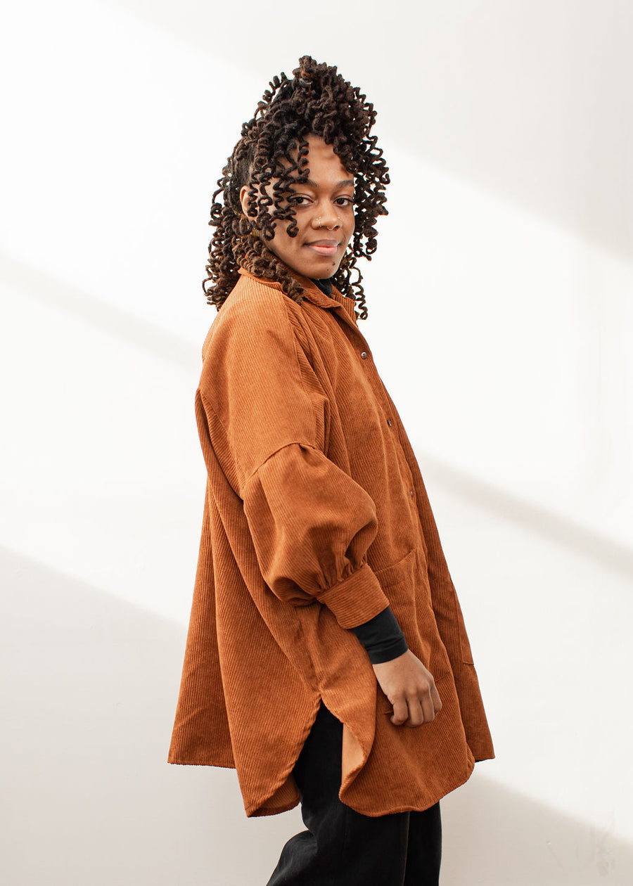 Side of model wearing a rust colored shacket