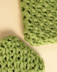 Two handmade dish scrubbies in green up close