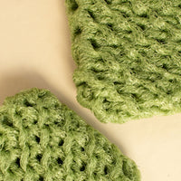 Two handmade dish scrubbies in green up close