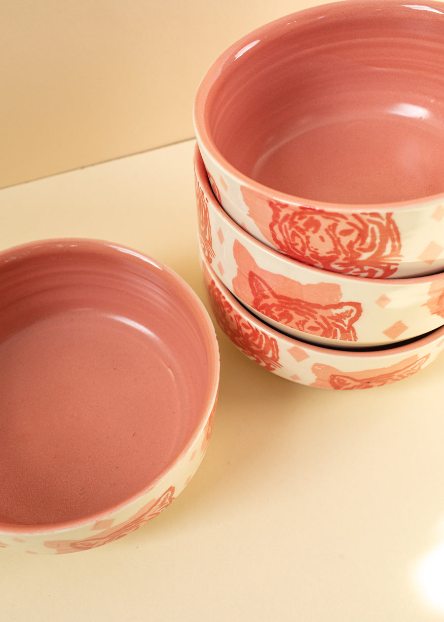 3 bowls stacked next to a lone bowl with pink tigers screen-printed on them