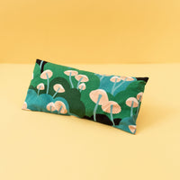 eye pillow with green and blue shades with pink mushrooms on it.