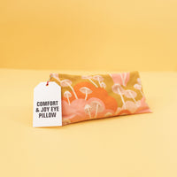 eye pillow with gold, pink and orange colors and white mushrooms on it