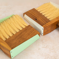 close up photo of two dust pan sets, one white farther away and the mint set closer to the camera.