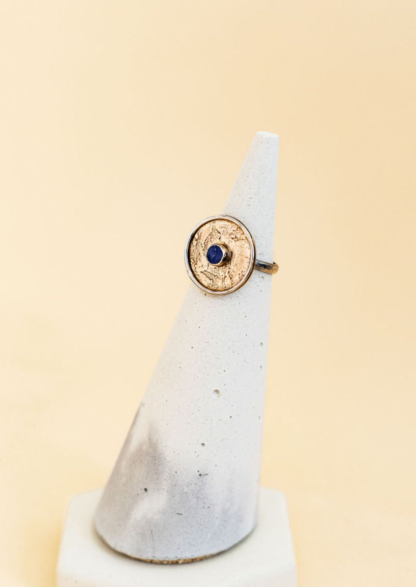 Mavi Ring by Claire Sommers Buck on a ceramic ring holder