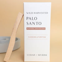 box of palo santo sticks with one leaning against it